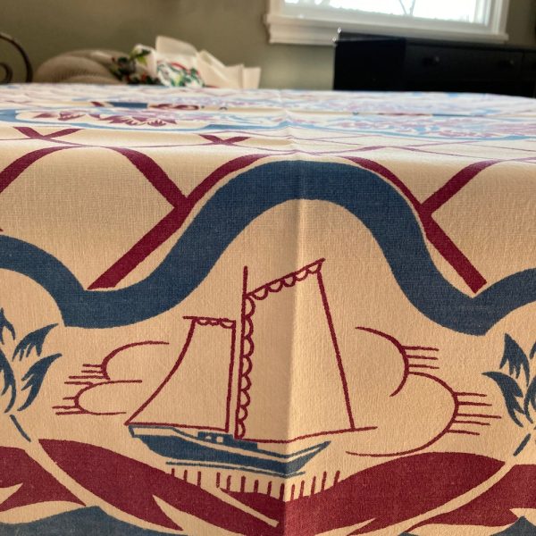 Whimsical vintage  tablecloth  of “Dutch Kids” frolicking on the shore. Purple  and blue tulips abound.